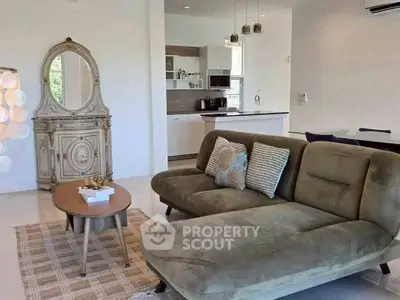 Stylish living room with modern furniture and open kitchen layout, perfect for contemporary living.