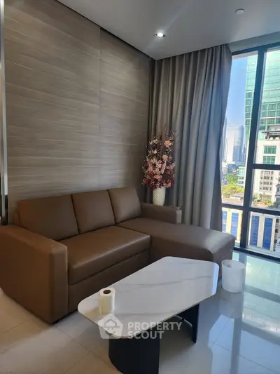 Modern living room with brown sofa, marble coffee table, and city view through large window.