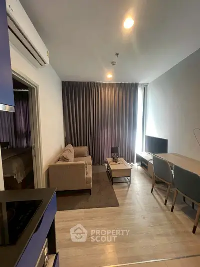 Modern living room with cozy sofa and dining area in open layout apartment.