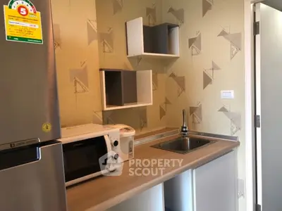 Modern kitchen with sleek design, featuring a compact layout and essential appliances for efficient living.