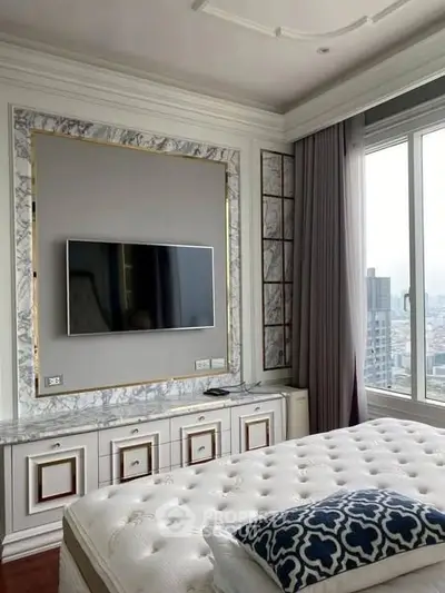 Luxurious bedroom with elegant decor and city view, featuring a mounted TV and plush bedding.
