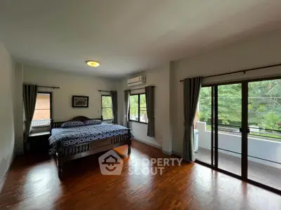 Spacious bedroom with balcony and serene view in modern home