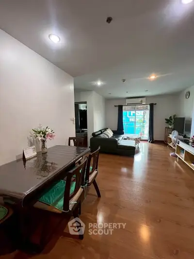 Spacious living room with wooden flooring and modern furniture in a cozy apartment.