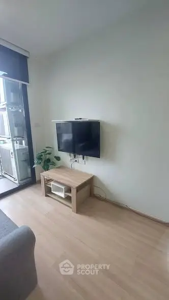 Modern living room with wall-mounted TV and balcony access