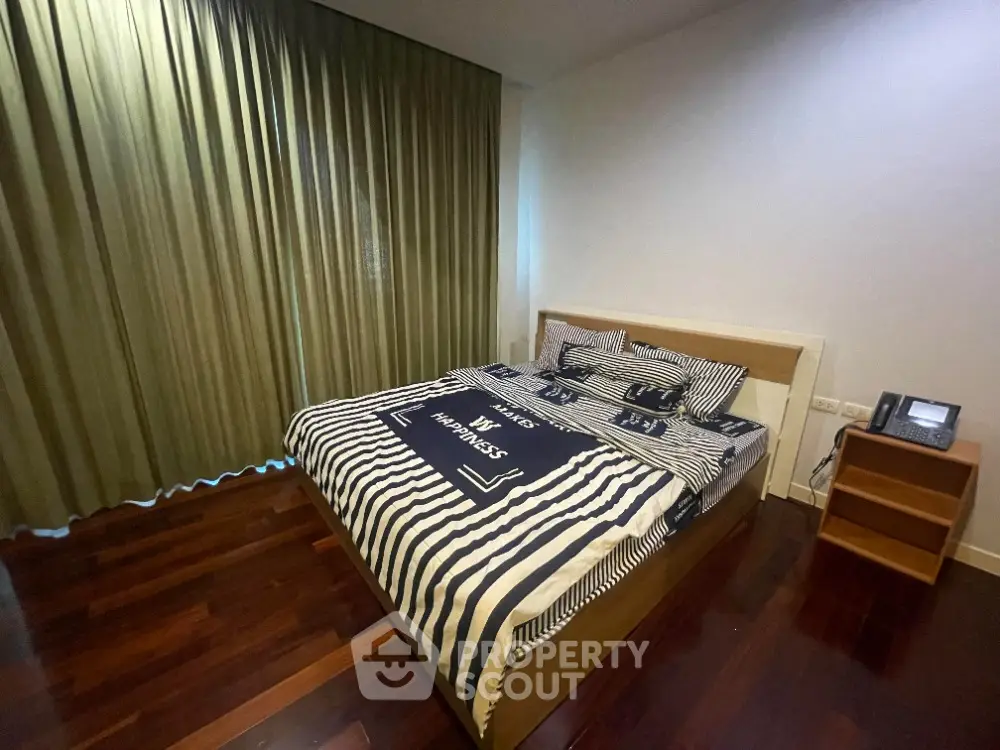 Spacious bedroom with elegant wooden flooring and modern decor