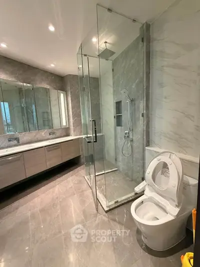 Luxurious modern bathroom with glass shower and sleek marble finishes