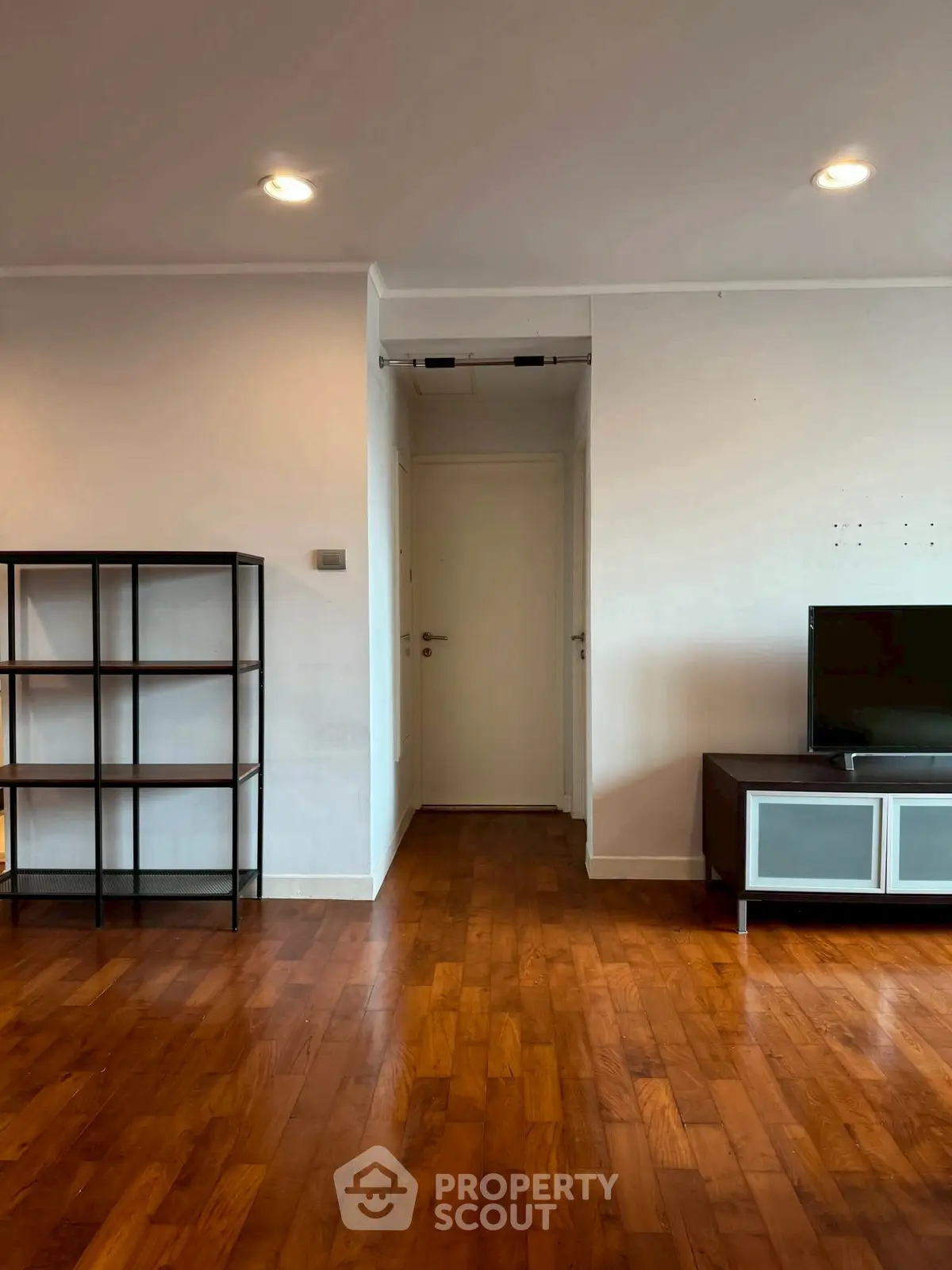 Spacious living room with wooden flooring and modern TV unit