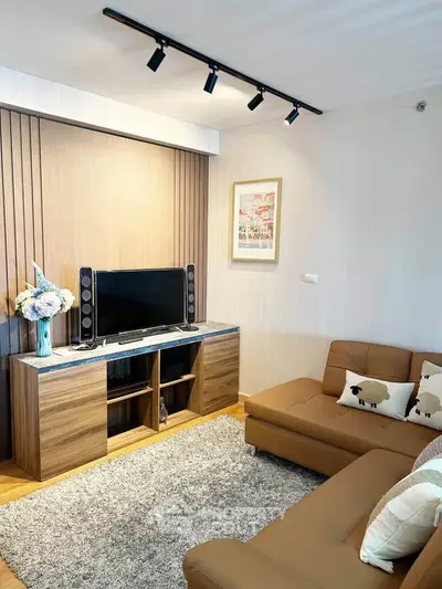 Modern living room with stylish decor, cozy sofa, and entertainment center in a chic apartment.