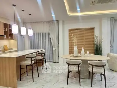 Modern kitchen and dining area with elegant lighting and marble flooring