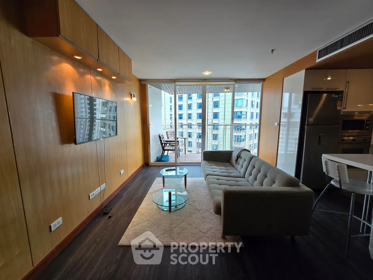 Modern living room with city view, stylish furniture, and open kitchen layout in a high-rise apartment.