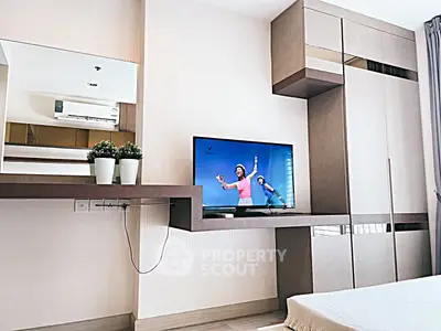 Modern bedroom with sleek built-in storage and wall-mounted TV