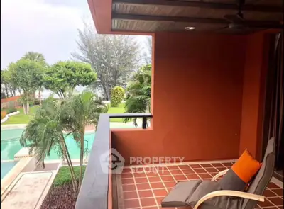 Charming balcony with pool and garden view, perfect for relaxation and outdoor enjoyment.