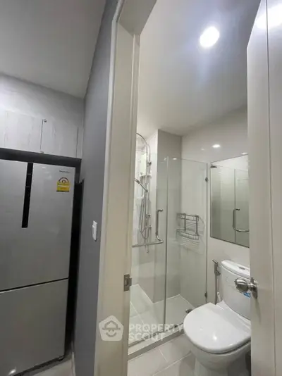 Modern compact bathroom with glass shower and sleek appliances