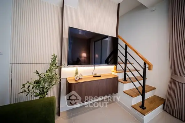 Modern living room with stylish staircase and mounted TV