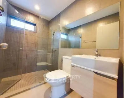 Modern bathroom with glass shower and sleek fixtures in a contemporary home.