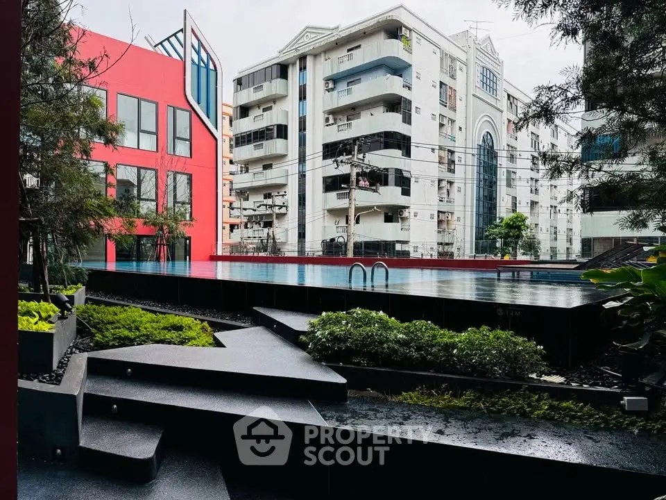 Modern urban apartment complex with sleek pool and lush greenery