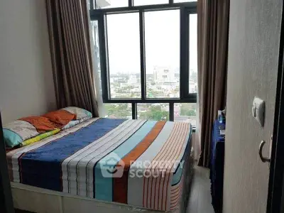 Modern bedroom with large windows offering a stunning city view, featuring a cozy bed and stylish decor.
