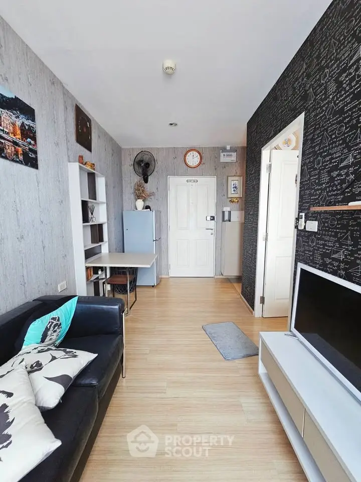 Modern living room with stylish decor and open layout, featuring a cozy sofa and entertainment unit.