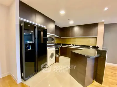 Modern kitchen with sleek black appliances and open layout in luxury apartment