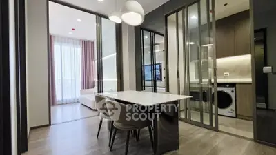 Modern apartment interior with dining area, living room, and kitchen featuring sleek design and natural light.