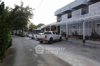 Modern building exterior with parking area and vehicles