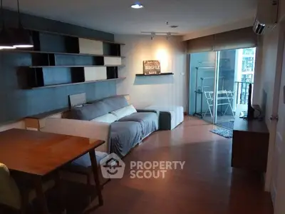 Modern living room with stylish furniture and balcony access in urban apartment.