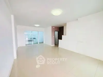 Spacious open-plan living room with modern tile flooring and ample natural light.