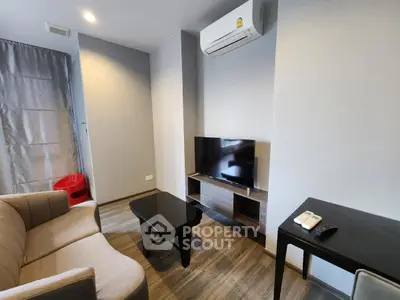 Modern living room with air conditioning and flat-screen TV in stylish apartment.
