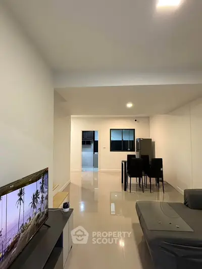 Spacious modern living room with sleek dining area and open kitchen layout.