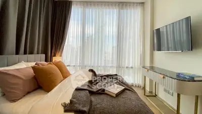 Luxurious bedroom with floor-to-ceiling windows and modern decor in high-rise apartment.