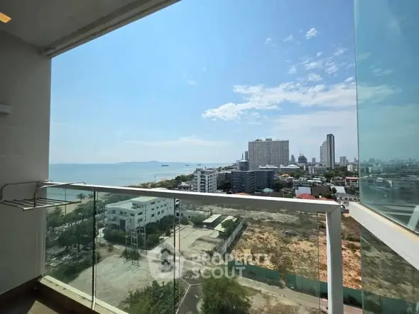 Stunning high-rise balcony view overlooking cityscape and ocean, perfect for urban living enthusiasts.
