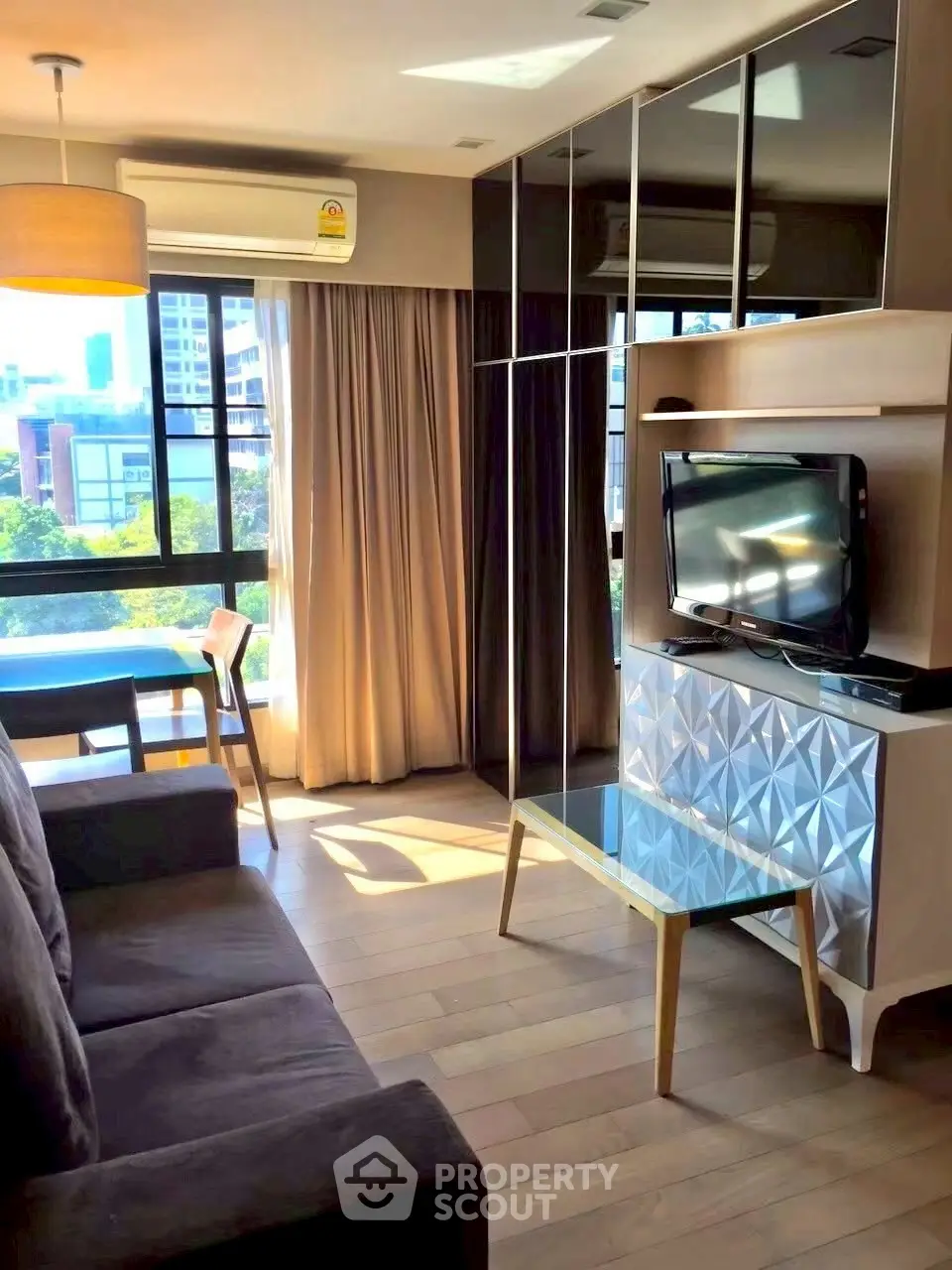 Modern living room with large windows and stylish furniture, offering a bright and inviting atmosphere.