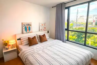 Bright and cozy bedroom with large window and stylish decor