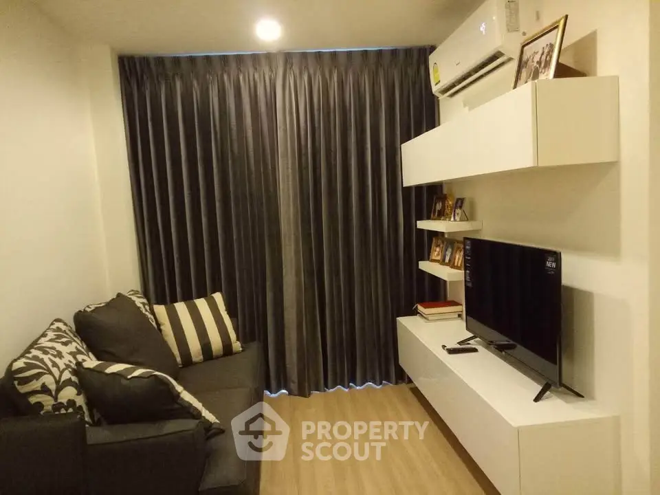 Cozy living room with modern decor, featuring a sleek TV unit and comfortable sofa, perfect for relaxation.
