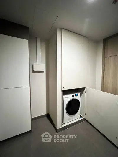 Modern laundry room with built-in washing machine and sleek cabinetry