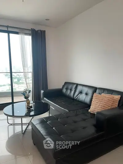 Modern living room with black leather sofa and city view balcony.
