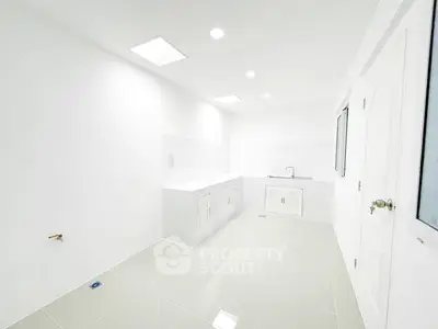 Spacious white kitchen with modern fixtures and ample storage space