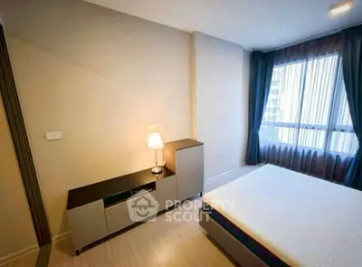 Cozy bedroom with modern furniture and large window for natural light.