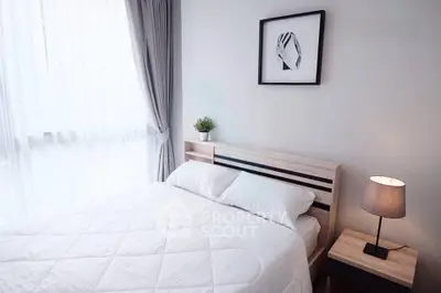 Cozy bedroom with modern decor, featuring a comfortable bed, stylish lamp, and elegant curtains.