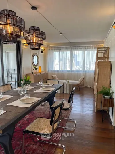 Elegant dining room with modern decor, wooden flooring, and large windows offering natural light.