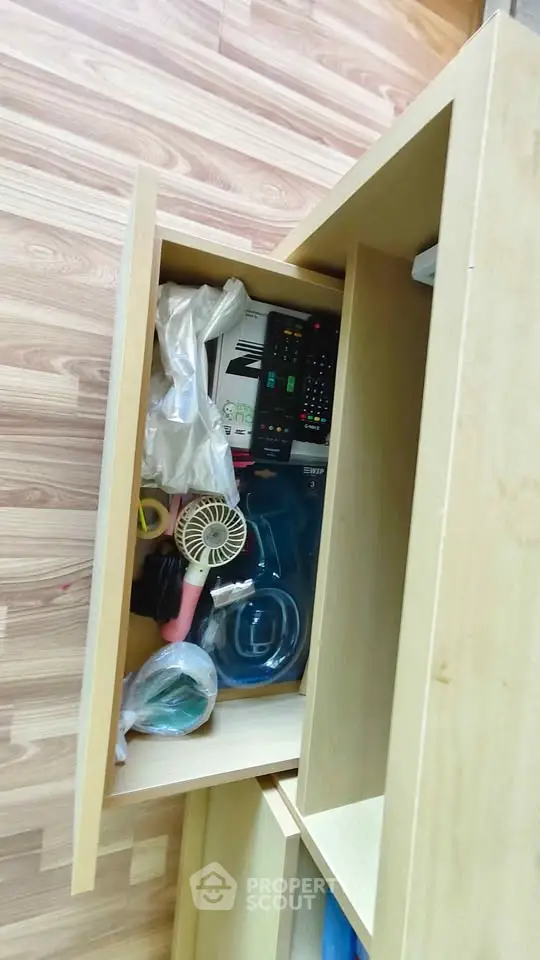 Spacious wooden storage unit with open drawers showcasing organized items on a sleek wooden floor.