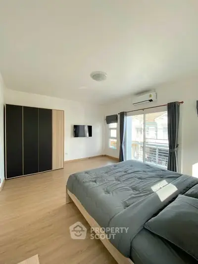 Spacious modern bedroom with balcony and sleek design