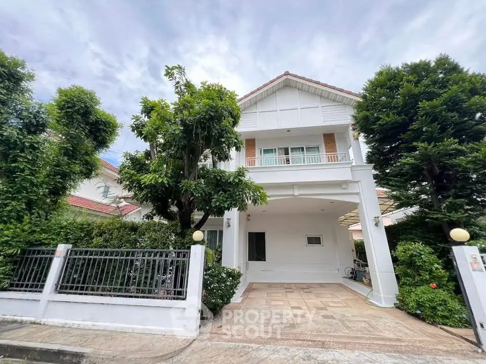Charming two-story house with lush greenery and spacious driveway