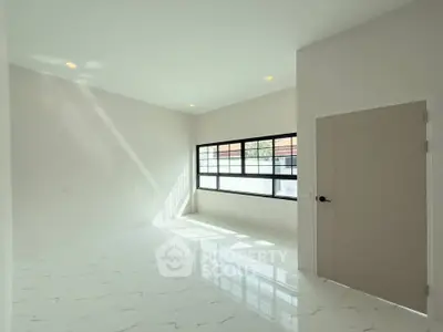 Spacious modern room with large windows and marble flooring, perfect for natural light lovers.