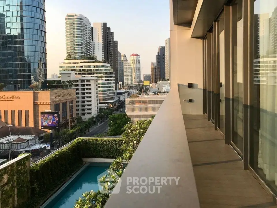Stunning cityscape view from modern balcony overlooking urban skyline and pool.