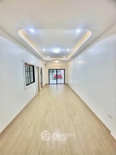 Spacious modern living room with elegant ceiling lights and large windows for natural light.
