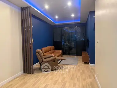 Modern living room with blue accent wall and leather seating