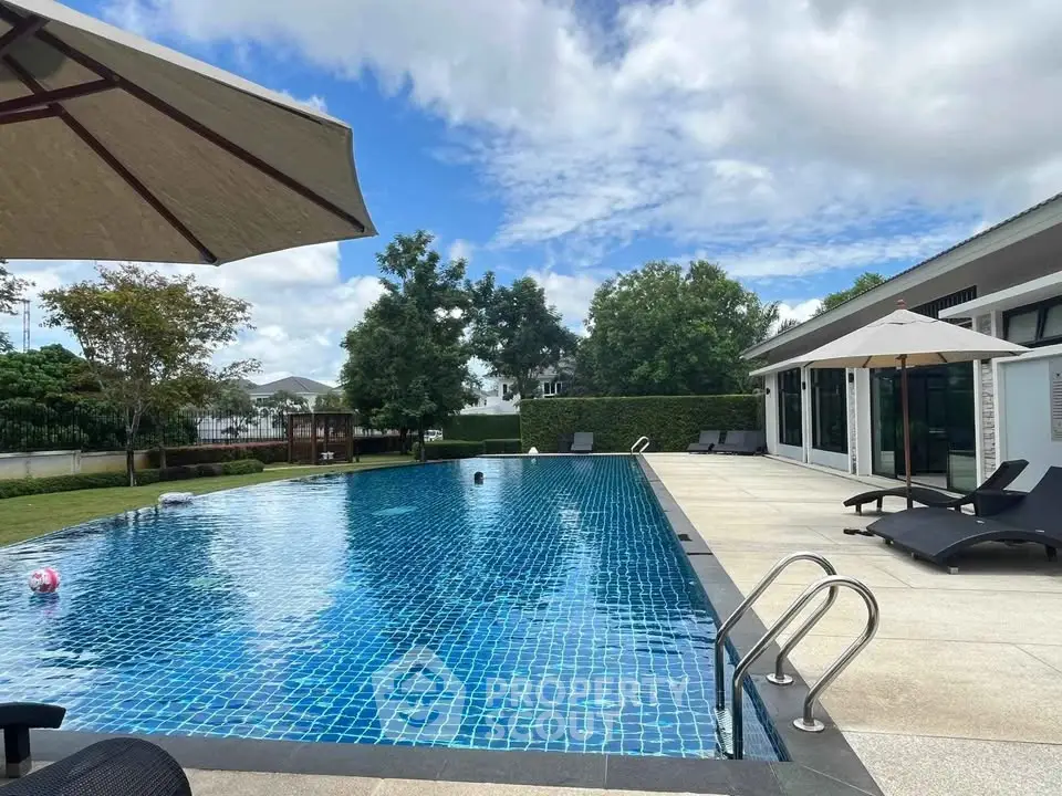 Luxurious poolside view with modern patio and lush greenery