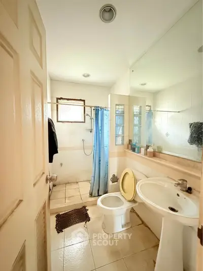 Bright bathroom with shower and large mirror, ideal for modern living.
