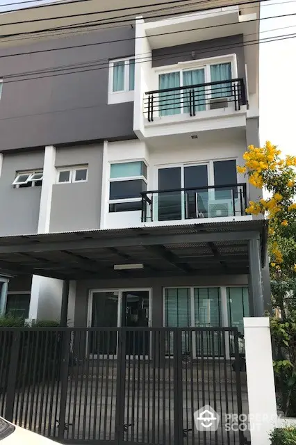 Modern three-story townhouse with sleek design and gated entrance